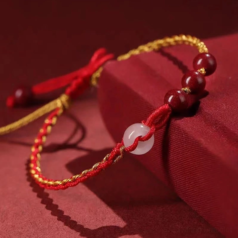 Cinnabar jade peace buckle bracelet on red display block showing jade buckle detail