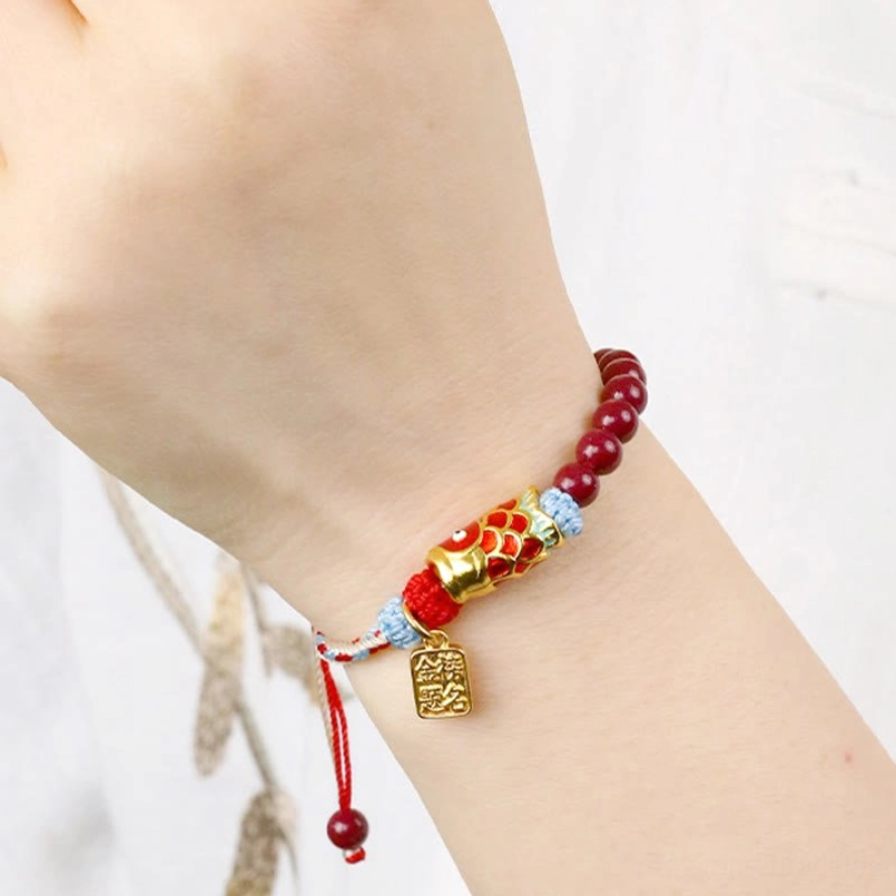 Cinnabar koi fish bracelet side view on wrist with engraved gold pendant