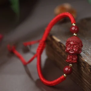 Cinnabar natal Buddha red string bracelet close-up side view with dark background