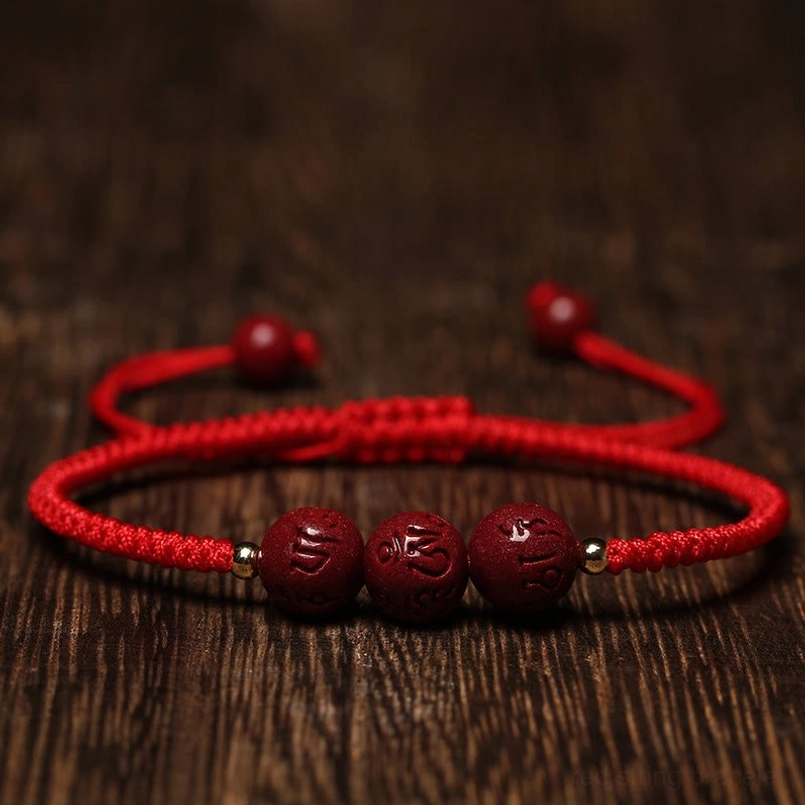 Cinnabar Om Mani Padme Hum blessing bracelet with red rope overhead view