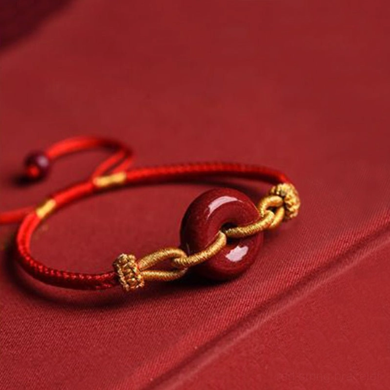 Red string cinnabar peace buckle bracelet with adjustable pull cord and gold accents