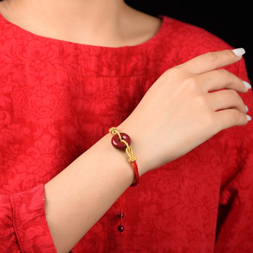 Woman wearing cinnabar peace buckle red string bracelet on wrist, lifestyle shot