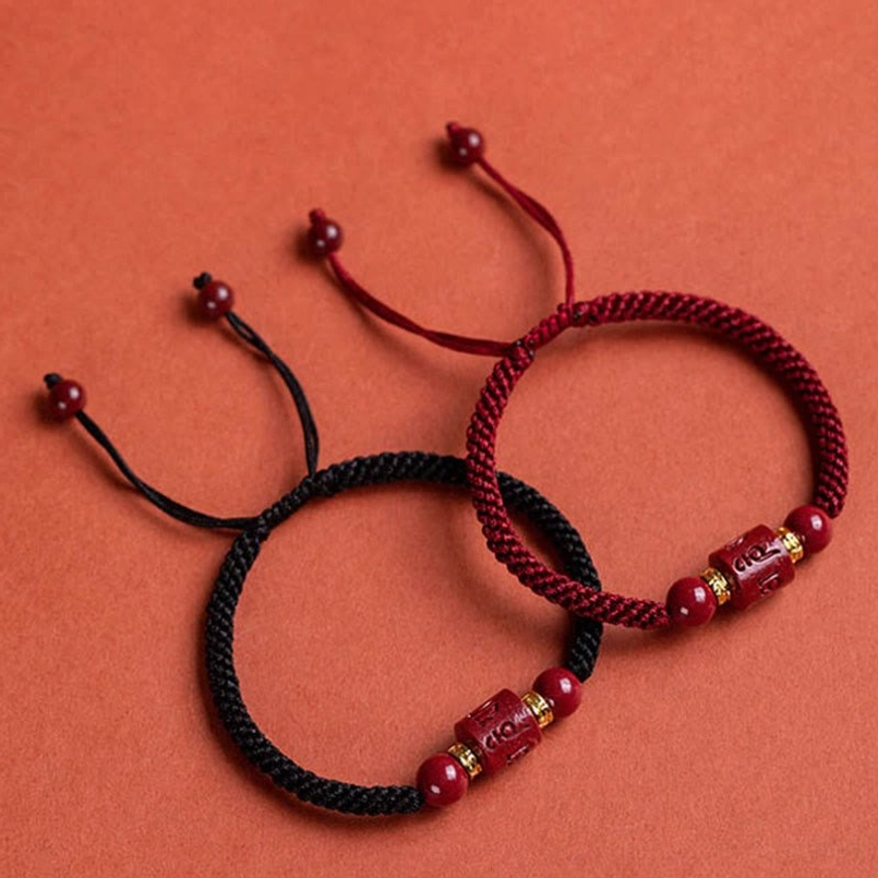 Natural raw cinnabar ore specimen next to om mani padme hum bracelet
