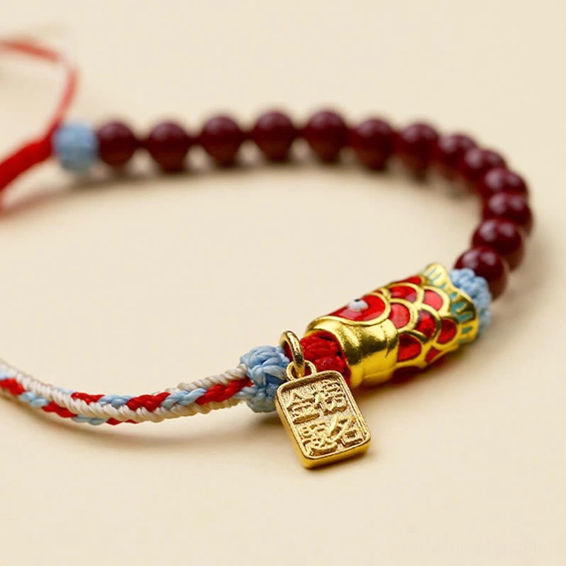 Red cinnabar beads bracelet with koi fish charm flat lay perspective