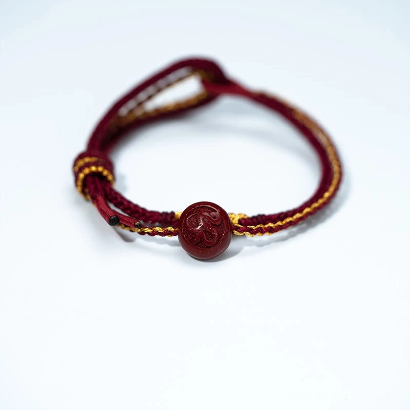 Eight-strand braided red string cinnabar bead bracelet flat lay front view