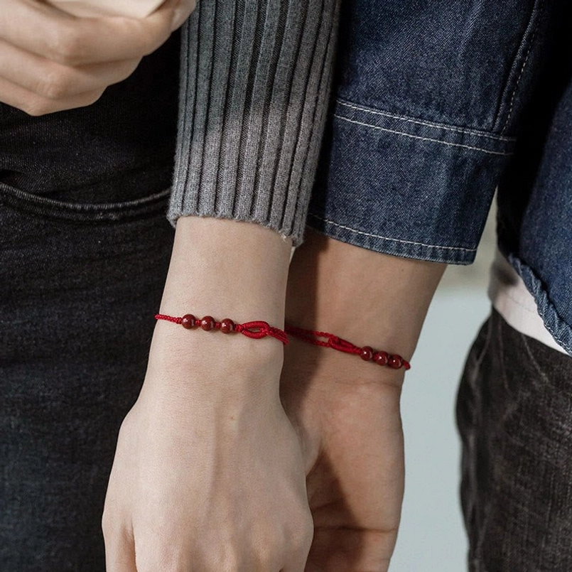 Cinnabar red string bracelet on neutral background product shot