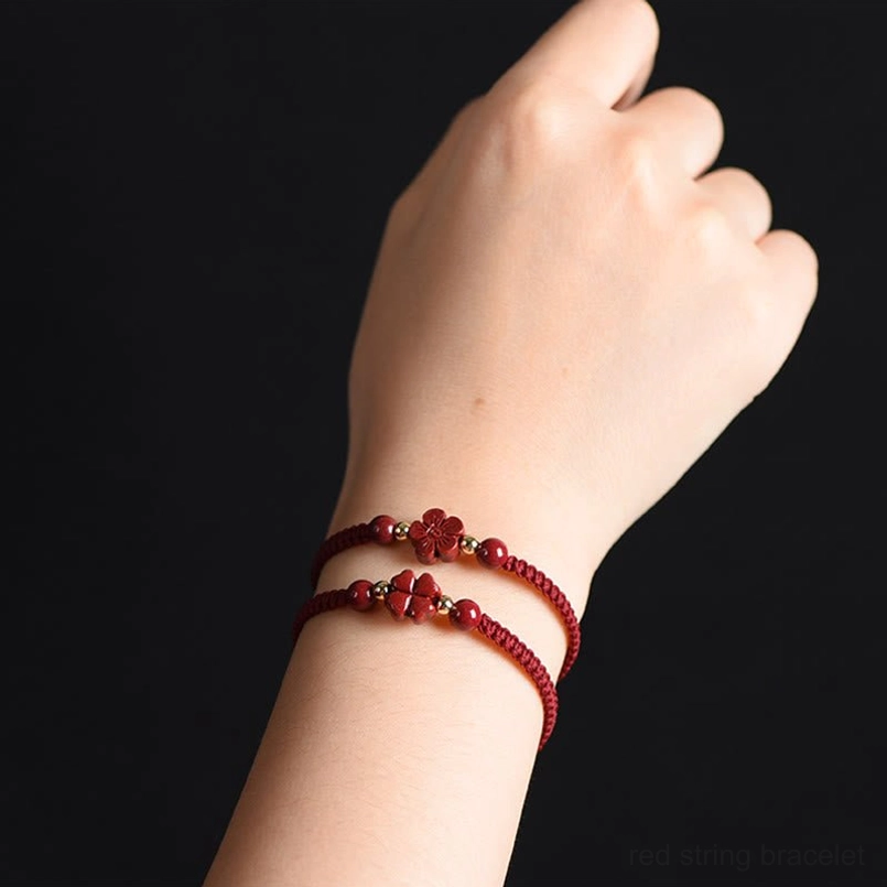 Dual-layer cinnabar red string bracelets worn on wrist showing layering style