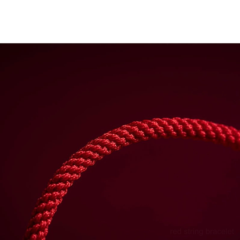 Red string bracelet with multiple cinnabar beads and gold spacers styled view