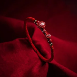 Handmade cinnabar red string bracelet with Ruyi charm and gold spacer beads, close-up side view