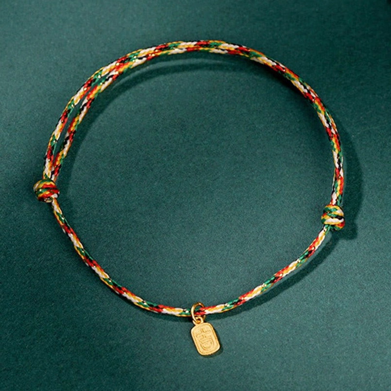 Circular multicolor lucky bracelet with gold Fu charm on dark green background