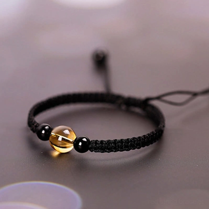Citrine black obsidian red string bracelet close up of gemstone surface