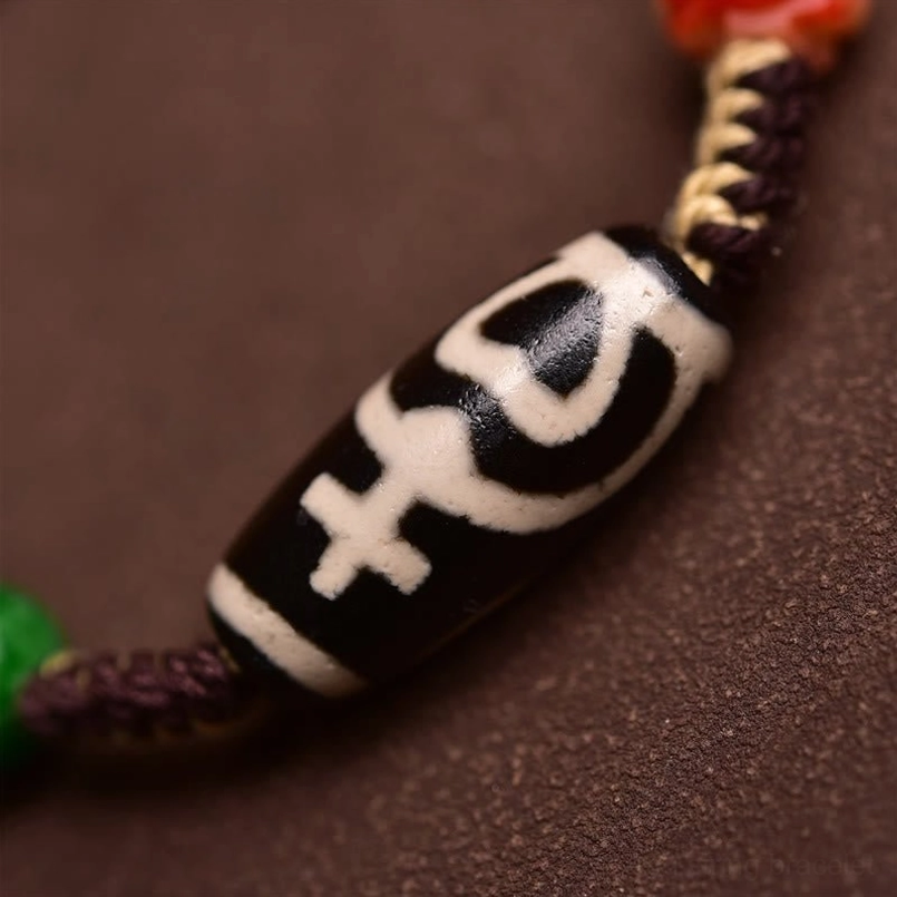 Close Up of Traditional Pattern Dzi Bead on Red String Bracelet