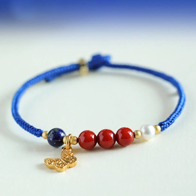 Close up of red agate lapis lazuli beaded blue string bracelet with gold butterfly charm