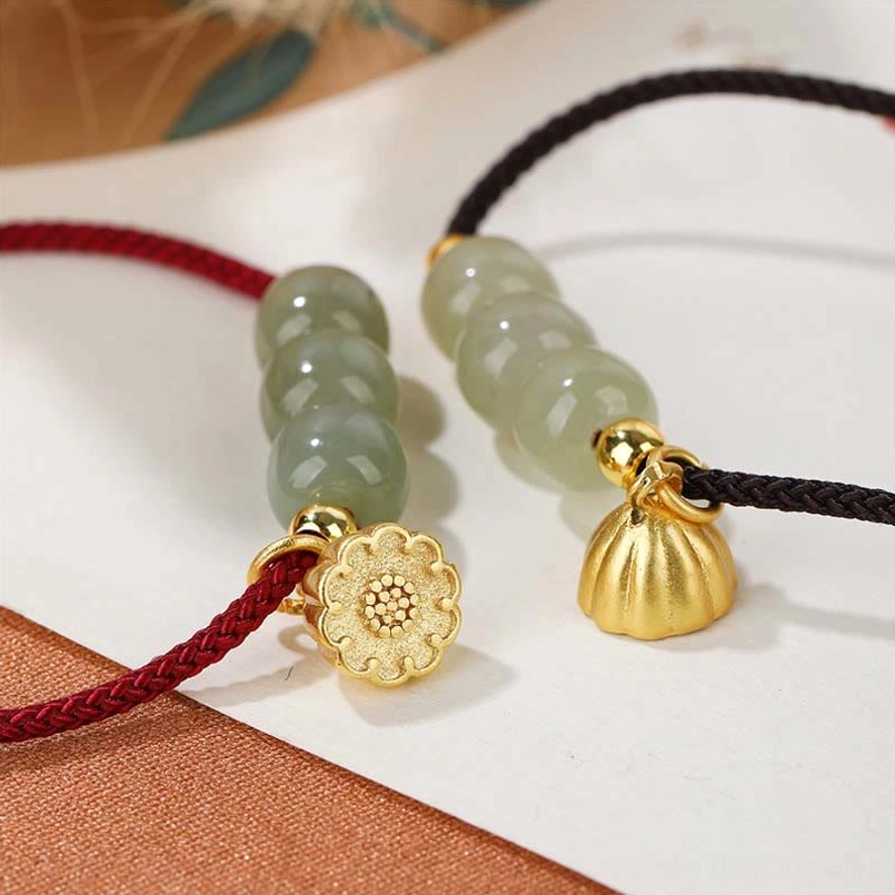 Close up shot of natural Hetian jade bead texture and lotus pod charm on braided string