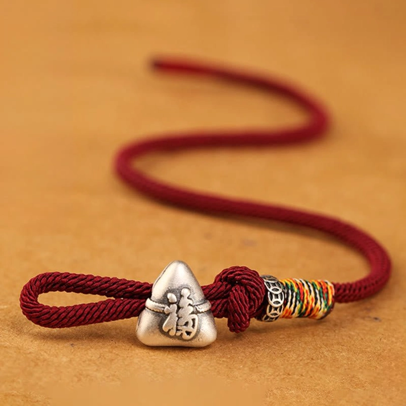 Unworn coiled dark red fu zongzi sterling silver bracelet side oblique view