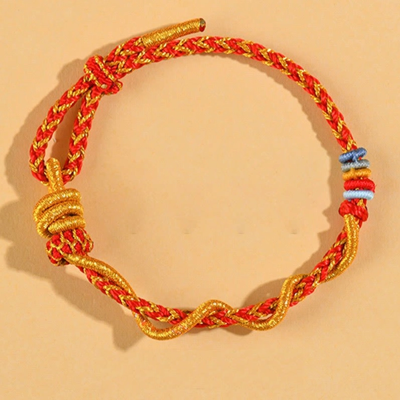 Colorful handmade luck bracelet with red and gold decorative knots and beads