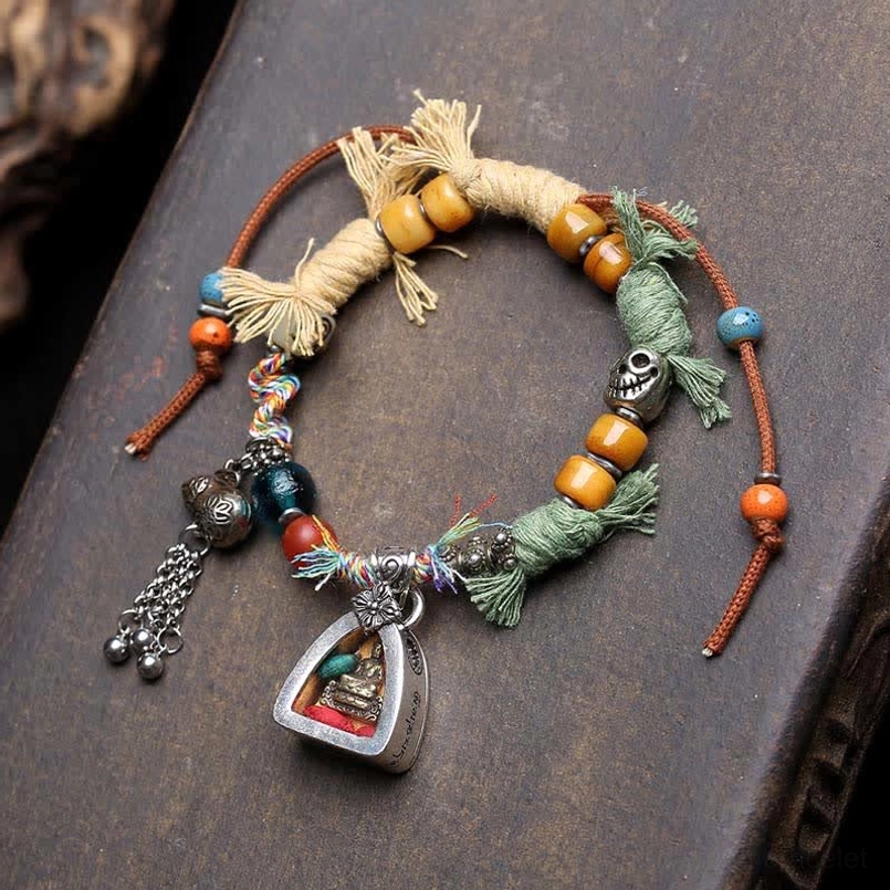 Colorful handmade red string bracelet with mixed beads and Buddha charm on wood
