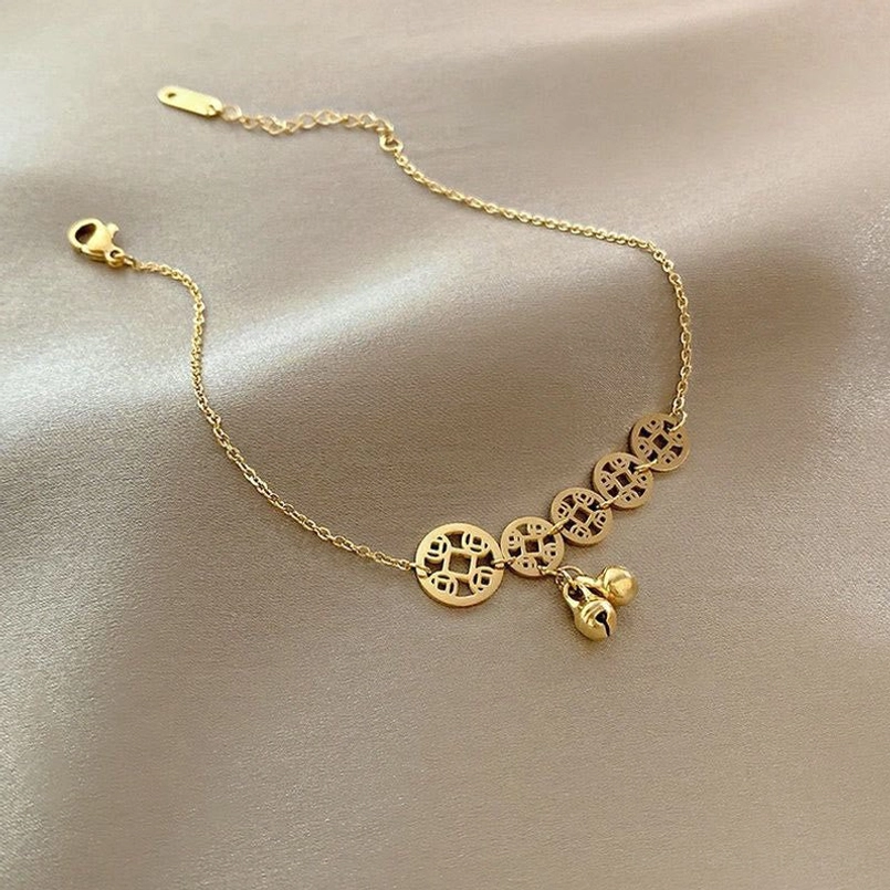 Flat lay top view of gold tone copper coins bell anklet with hollow coin charms and lobster clasp