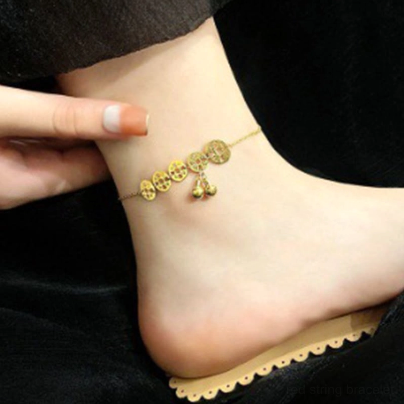 Gold copper coins bell anklet worn on ankle with wooden background