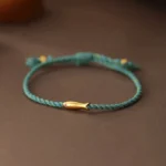 Copper koi fish luck bracelet turquoise braided rope with gold charm flat lay top view