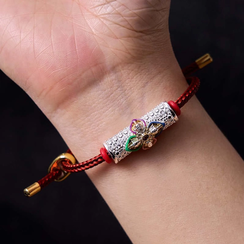 Red string bracelet worn on human wrist showing adjustable clasp and how it sits on skin