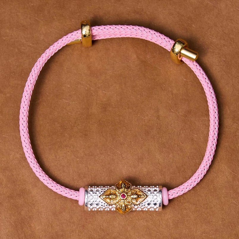 Copper luck bracelet with pink cord and detailed enamel flower charm design