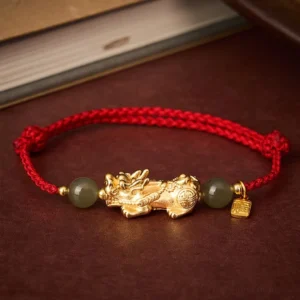 Copper Pi Xiu Fu character Hetian Jade red string bracelet flat lay top view on dark red table