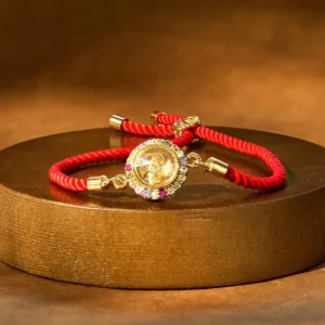 Copper windmill red string bracelet with rotating charm on wooden display stand, front overhead view