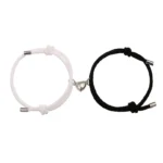 Magnetic couple red string bracelets set with heart clasps, black and white woven rope, flat lay view