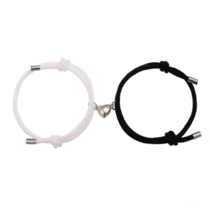 Magnetic couple red string bracelets set with heart clasps, black and white woven rope, flat lay view
