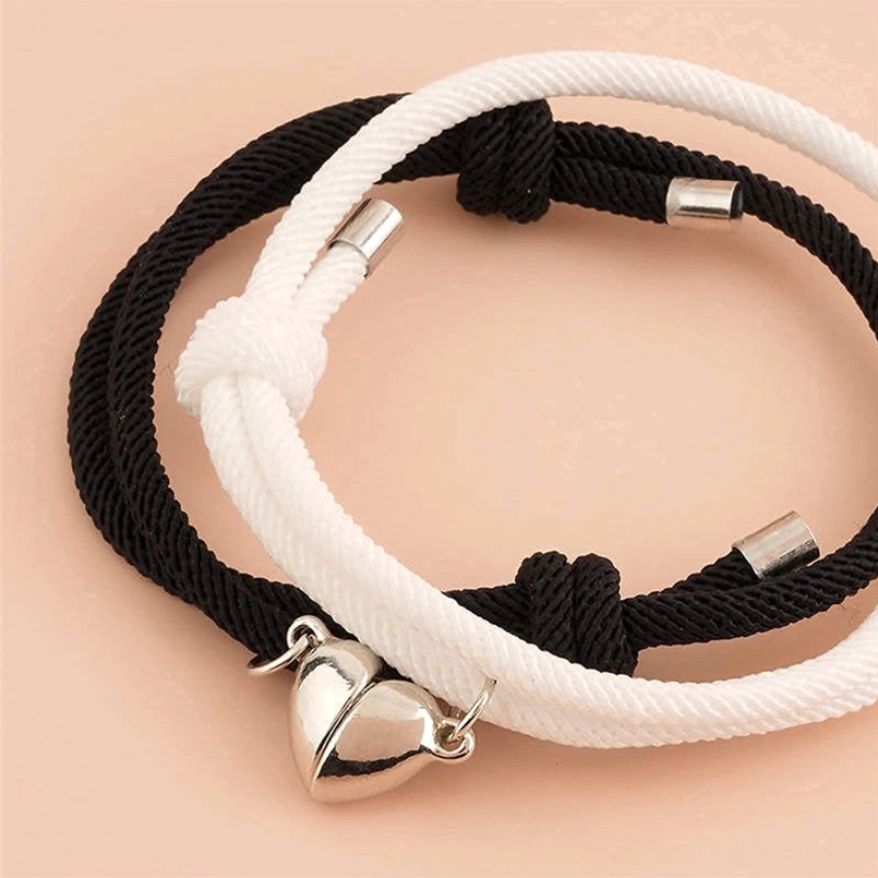 Magnetic couple red string bracelets with heart clasp, metal adjusters, flat lay top-down view