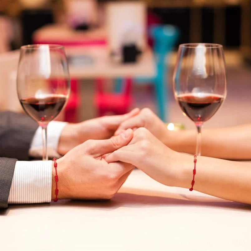 Red string bracelets worn on couple wrists intimate relationship moment