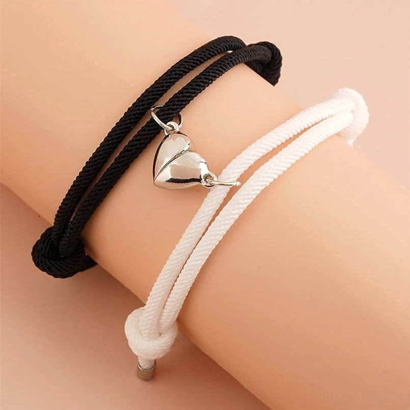 Couple wearing magnetic red string bracelets on wrists, close-up adjustable knot detail