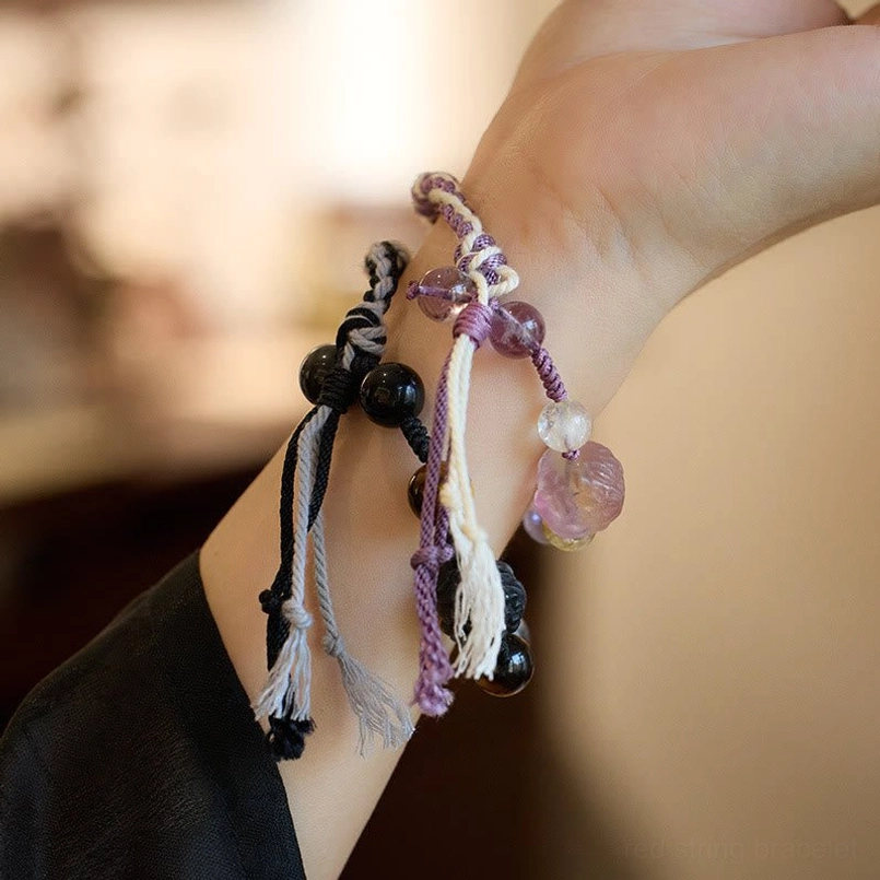 Two styles of gemstone red string bracelets worn on wrist close up
