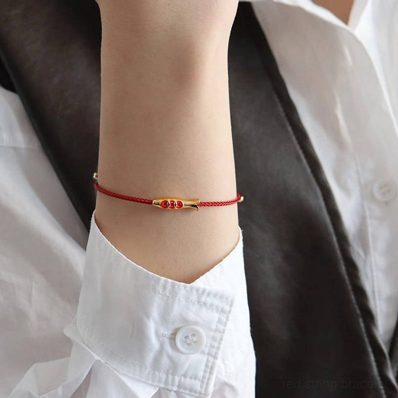 Minimal koi fish red string bracelet on wrist with formal white shirt