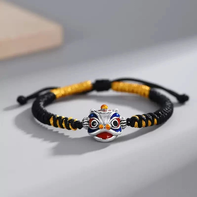 Dancing Lion red string bracelet with black and yellow woven cord and silver enamel charm detail