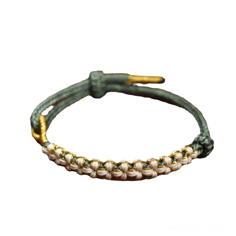 Closeup detailed view of dark green peach blossom knot woven red string bracelet