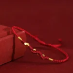 Dark red 999 gold year of the snake red string bracelet on wine red background with gift box