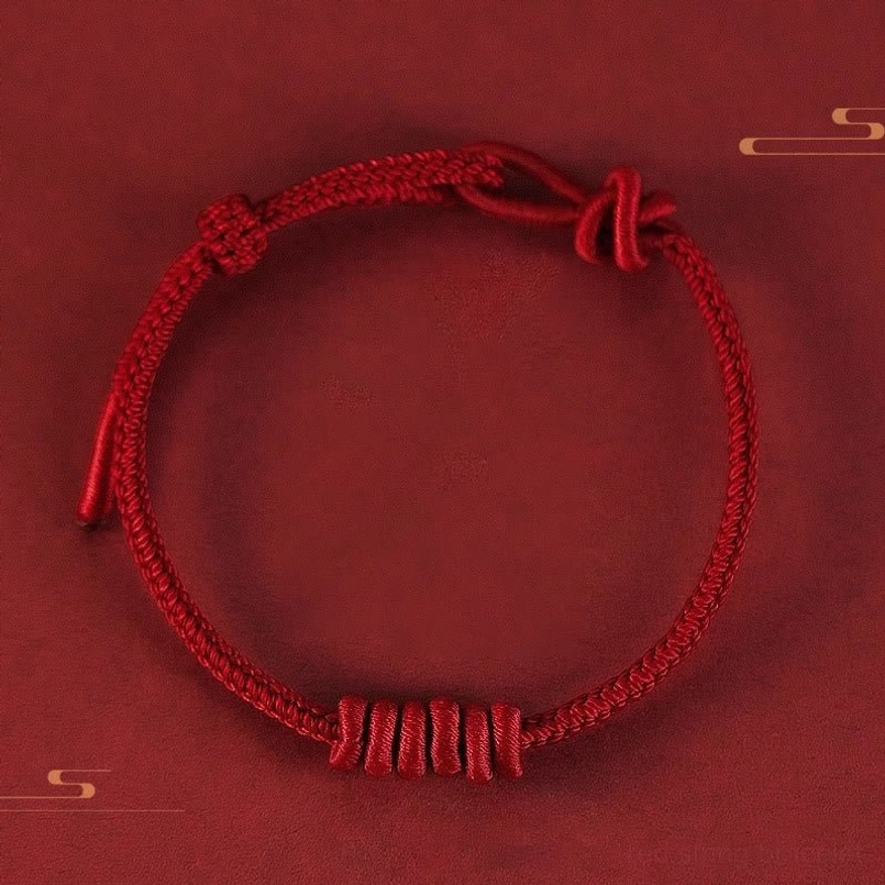 Dark red eight stranded red string bracelet flat lay on dark red background