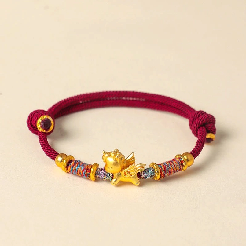 Dark red braided string bracelet with gold horse charm close up