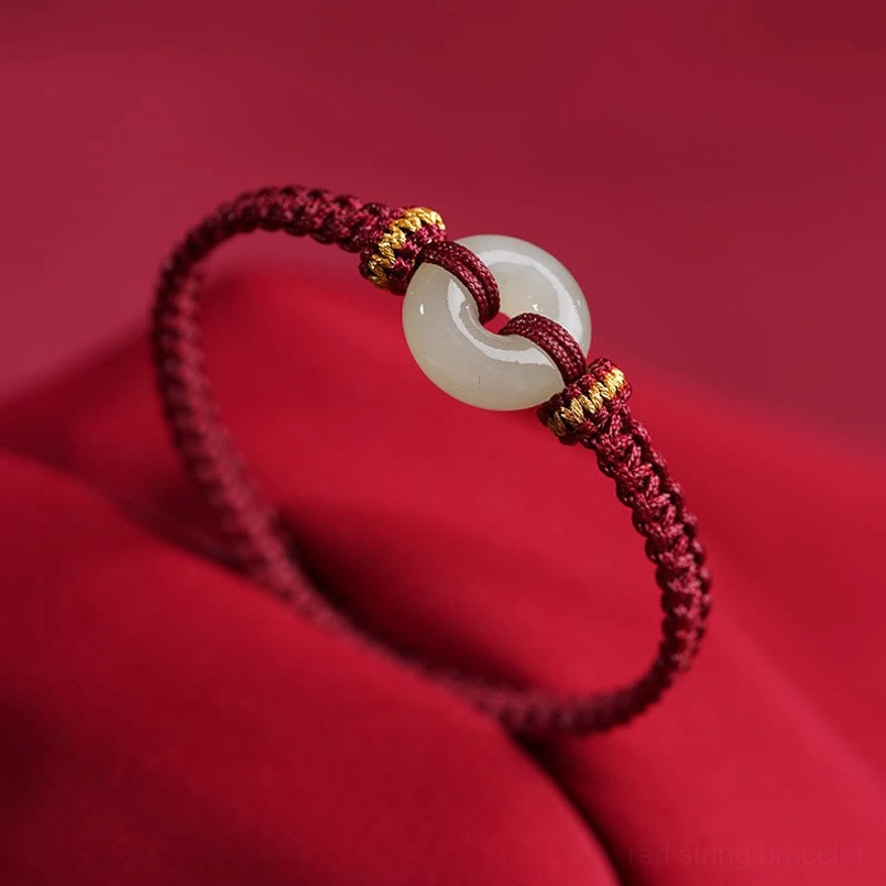 Dark red braided red string bracelet with natural jade peace buckle close up