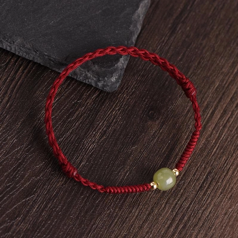 Dark red rope hetian jade gold beads bracelet flat lay close-up