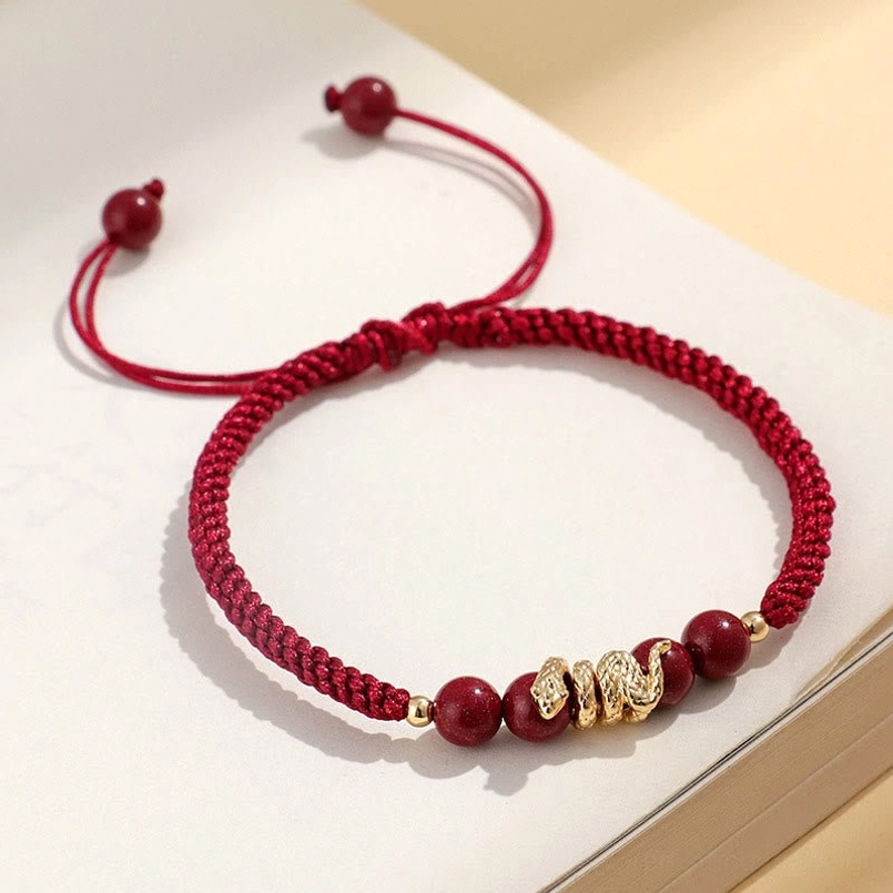 Flat lay view of dark red rope Year of Snake cinnabar braided bracelet