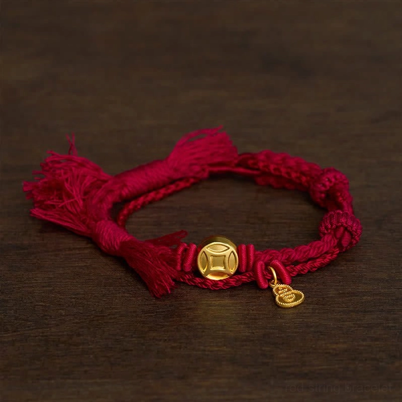 Dark Red Rope Lucky Bracelet with Gold Coin and Gourd Charms on Dark Wooden Table