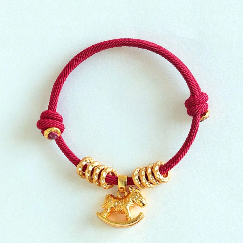 Dark red woven string horse charm bracelet with small purple accent beads on white background