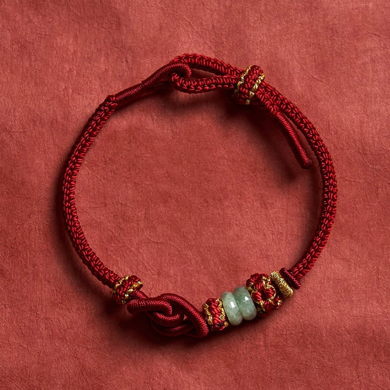 Dark red string jade bracelet with light green jade beads overhead view