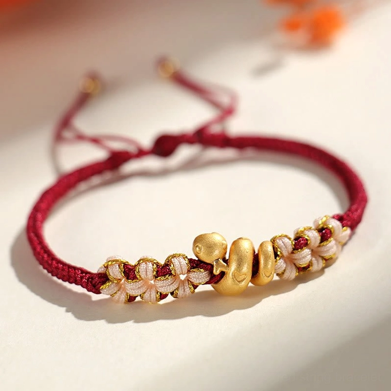 Dark red cord year of the snake luck bracelet top down flat lay view