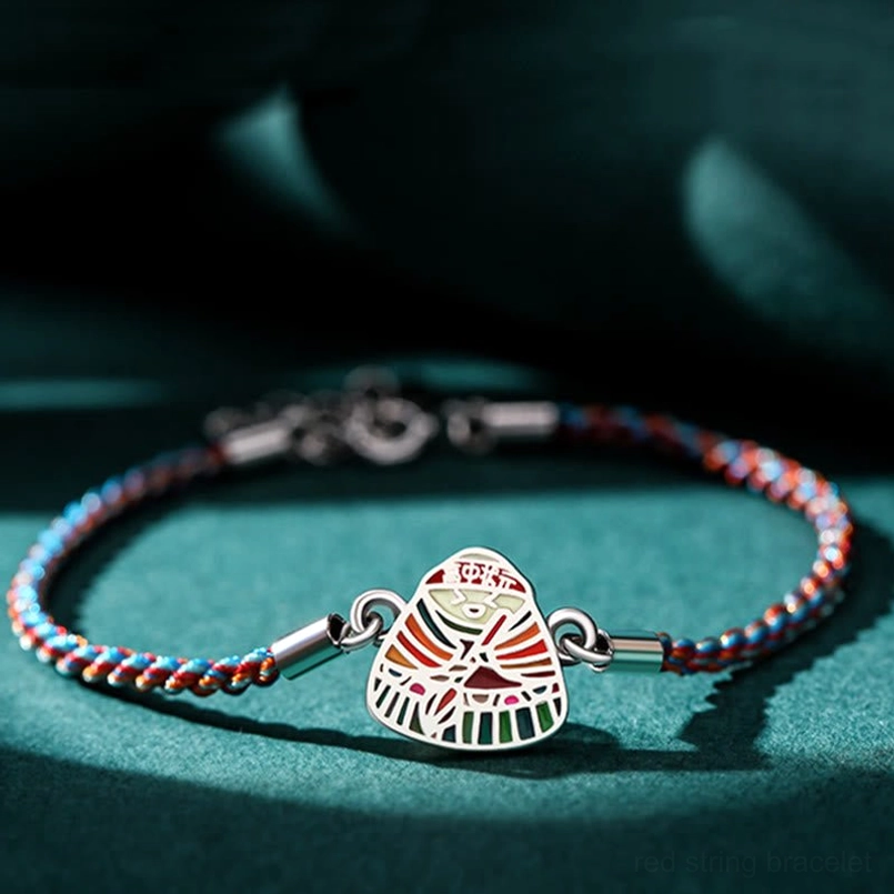 Close up of detailed multicolor enamel zongzi pendant sterling silver red string bracelet
