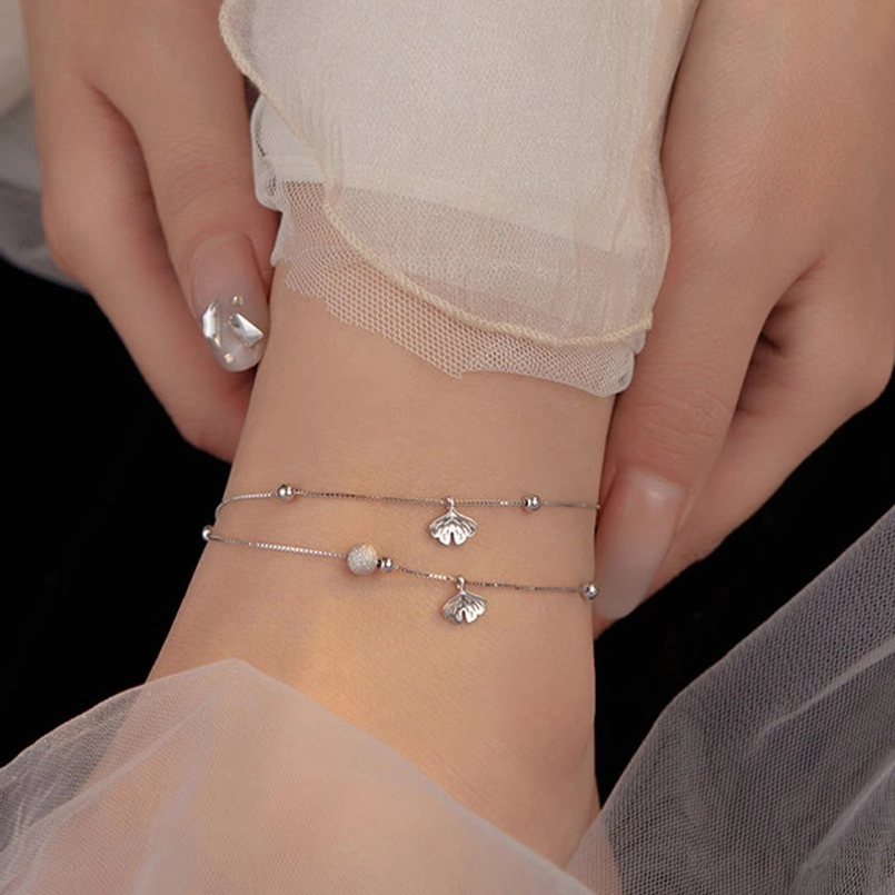 Beaded double chain ginkgo leaf anklet on ankle, feminine styling