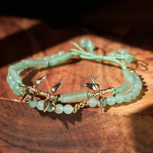 Double layer green aventurine bamboo red string bracelet on wooden tabletop